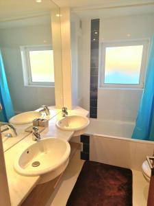 een badkamer met 2 wastafels, een bad en een spiegel bij Varandas do Carvoeiro in Carvoeiro