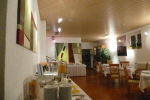 une salle à manger avec des tables, des chaises et des plaques blanches dans l'établissement Hotel Alpenblick Garni, à Überlingen