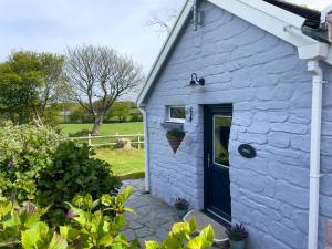 a blue stone cottage with a blue door at Canllefaes Cottages in Cardigan