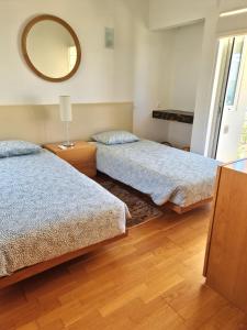 een slaapkamer met twee bedden en een spiegel aan de muur bij Varandas do Carvoeiro in Carvoeiro