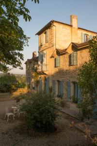 uma velha casa de pedra com uma mesa em frente em Château Du Tasta em Camblanes-et-Meynac