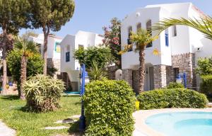 a villa with a swimming pool and palm trees at Marphe Hotel in Datca