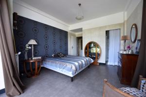 a bedroom with a large bed and a mirror at Château Du Tasta in Camblanes-et-Meynac