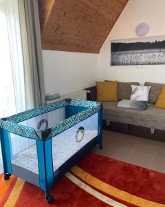 um berço azul num quarto com um sofá em Chestnut Hill- Zalakaros em Zalakaros
