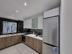 Una cocina con gabinetes de madera y refrigerador. en Arman Group Lannister, en Atenas