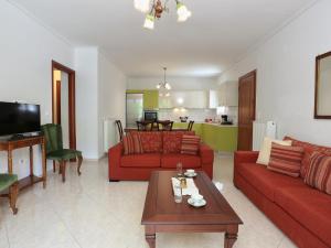 a living room with two red couches and a table at Frida's House in Kariá