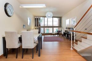 Un comedor con una mesa y sillas y un reloj. en Marble Apartments, en San Andrés 40 fotos más