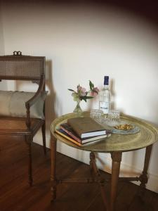 una mesa con una botella de vino y un libro en La Maison Mûrier, en Chef-Boutonne