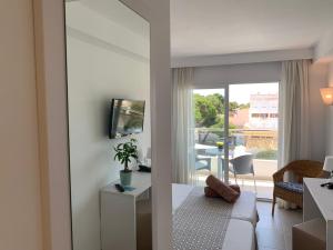 a living room with a view of a balcony at Hotel Chevy & Suites in Cala Ratjada