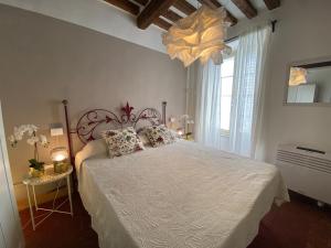 een slaapkamer met een bed met een witte sprei bij Cactus Suite in Pisa