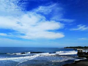 Playa El Obispo B La Marea building La Libertad في لا ليبرتاد: شاطئ مع المحيط وسماء زرقاء وغيوم