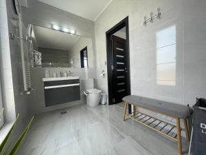 ein Badezimmer mit einem Waschbecken, einem WC und einem Spiegel in der Unterkunft DreamView Mamaia SummerApt in Mamaia