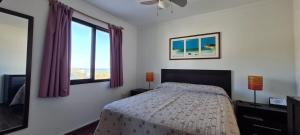 una camera da letto con un letto e una grande finestra di Lindas Vistas Apartment a Piriápolis
