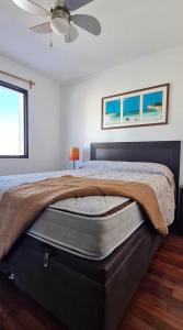 1 dormitorio con 1 cama y ventilador de techo en Lindas Vistas Apartment, en Piriápolis