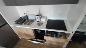 een kleine keuken met een wastafel en een tv bij New Adria mobile Home - camp Vala in Orebić