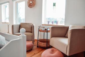 ein Wohnzimmer mit 2 Stühlen und einem Sofa in der Unterkunft Damwildfarm in Rollerbü Südschweden in Tyringe