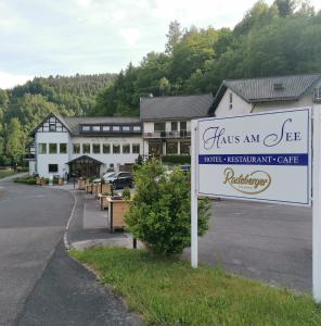 a sign in front of a large building with a sign at Hotel Haus am See in Simmerath