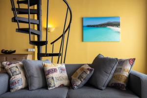 a gray couch with pillows in a living room at Punda City Centre Penthouse in Willemstad