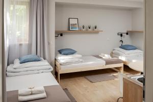 a room with two beds and a sink at Apart Hostel S8 in Blizne Jasińskiego