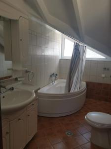 y baño con bañera, lavabo y aseo. en Villa Lithitsa, en Parga