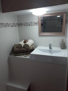 a bathroom with a sink and a mirror and towels at Casa de Bello in Tortosa
