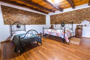 2 camas en una habitación con una pared de ladrillo en Chalet Giuel en Bărcuţ