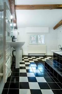 a bathroom with a sink and a black and white checkered floor at Les Chemins de Berdis in Montfort-en-Chalosse