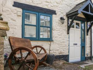 a building with a blue window and a wooden wagon at Mews Cottage in Minehead