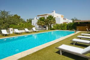 a swimming pool with lounge chairs and a villa at Villa Munt Blanc Ibiza in Puig D’en Valls