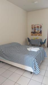 a bedroom with a bed with a checkered blanket at Apartamento no Jardim botânico in Brasilia