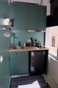 a kitchen with green cabinets and a sink at Central urban studio A in Athens