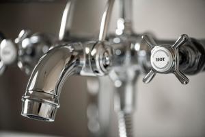 a chrome bathroom faucet with a hot button on it at Château de la Chapelle in Anthisnes