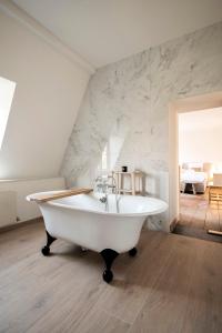 a white bath tub sitting in a room at Château de la Chapelle in Anthisnes