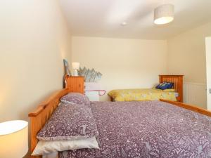 un dormitorio con una cama y una colcha en Blue Skies Cottage, en Arbroath
