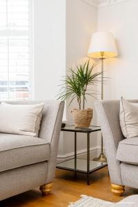 uma sala de estar com um sofá e uma mesa com uma planta em 6 Woodville em The Mumbles