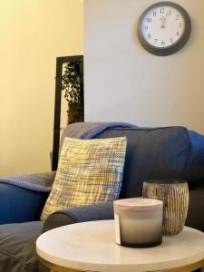 a living room with a couch and a clock on the wall at Stylish -2 Bed -Heart of the City - Parking- Wi-fi- Award Winning- Grade II Listed in Norwich