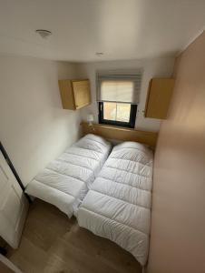 um pequeno quarto com duas camas brancas em Joli Chalet avec grande terrasse et accès piscine em Rocbaron