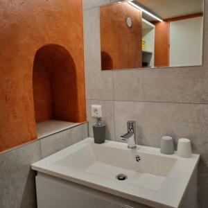 un bagno con un lavandino bianco e uno specchio di Ferienwohnung Martin a Rattenberg