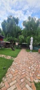 a brick path with a statue of a woman with an umbrella at Enpi Lake Resort in Iaşi