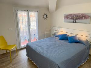 a bedroom with a blue bed and a window at Vista Mare Borgo Peri in Imperia