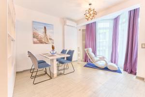 a dining room with a table and chairs at Rainbow sea view apartment Spa n Pool resort - parking in Mamaia