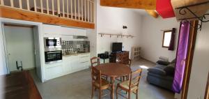 cocina y sala de estar con mesa y sillas en Le Tras Castel, 4 places jardin piscine, en Saint-Jean-de-Buèges