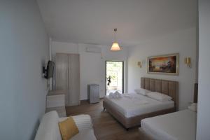 Habitación de hotel con 2 camas y sofá en Bujtina Eleni, en Himare