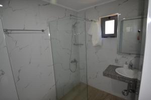 y baño con ducha acristalada y lavamanos. en Bujtina Eleni, en Himare