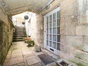 uma entrada para um edifício de pedra com uma porta e escadas em Dollar Ward House Basement em Cirencester