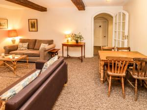 a living room with a couch and a table at Dollar Ward House Basement in Cirencester