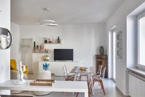 a living room with a table and chairs and a tv at EQUORUM Delicious Suite - Ostuni Centro in Ostuni