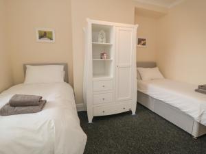 sypialnia z 2 łóżkami i białą szafką w obiekcie Westgate w mieście Guisborough