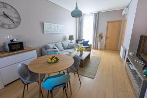 a living room with a table and a couch at Jomas street apartment in Jūrmala