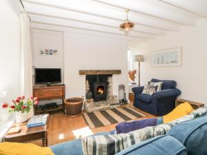 a living room with a couch and a fireplace at Oak Cottage in Plymouth